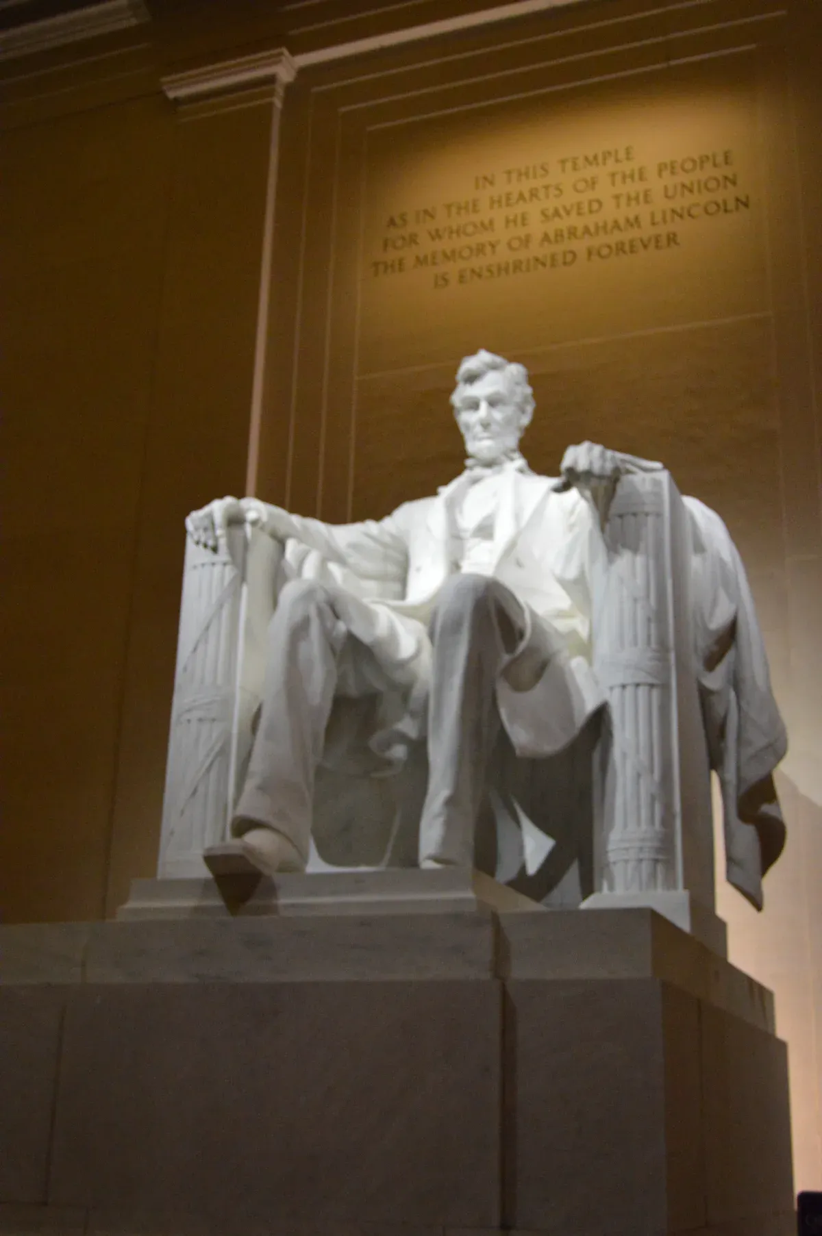 The seated statue of Abraham Lincoln lit at night inside the Lincoln Memorial, a stop on night Washington DC tours for seniors